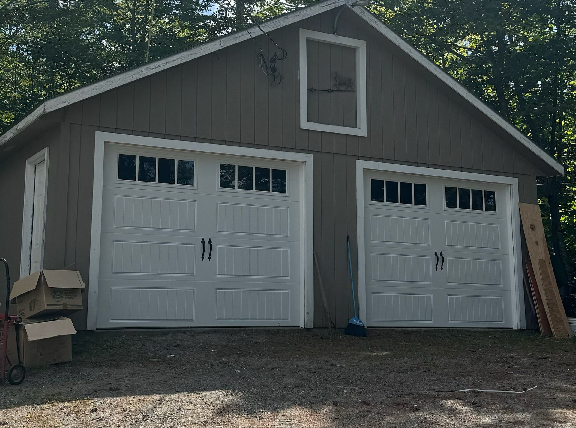 A large garage with two white garage doors is being built.