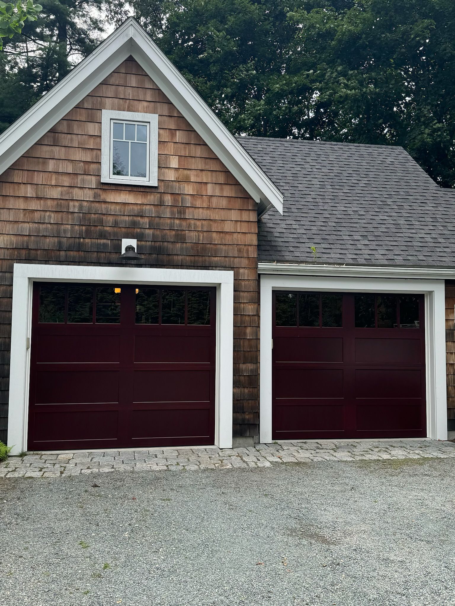 There are two garage doors on the side of a house.