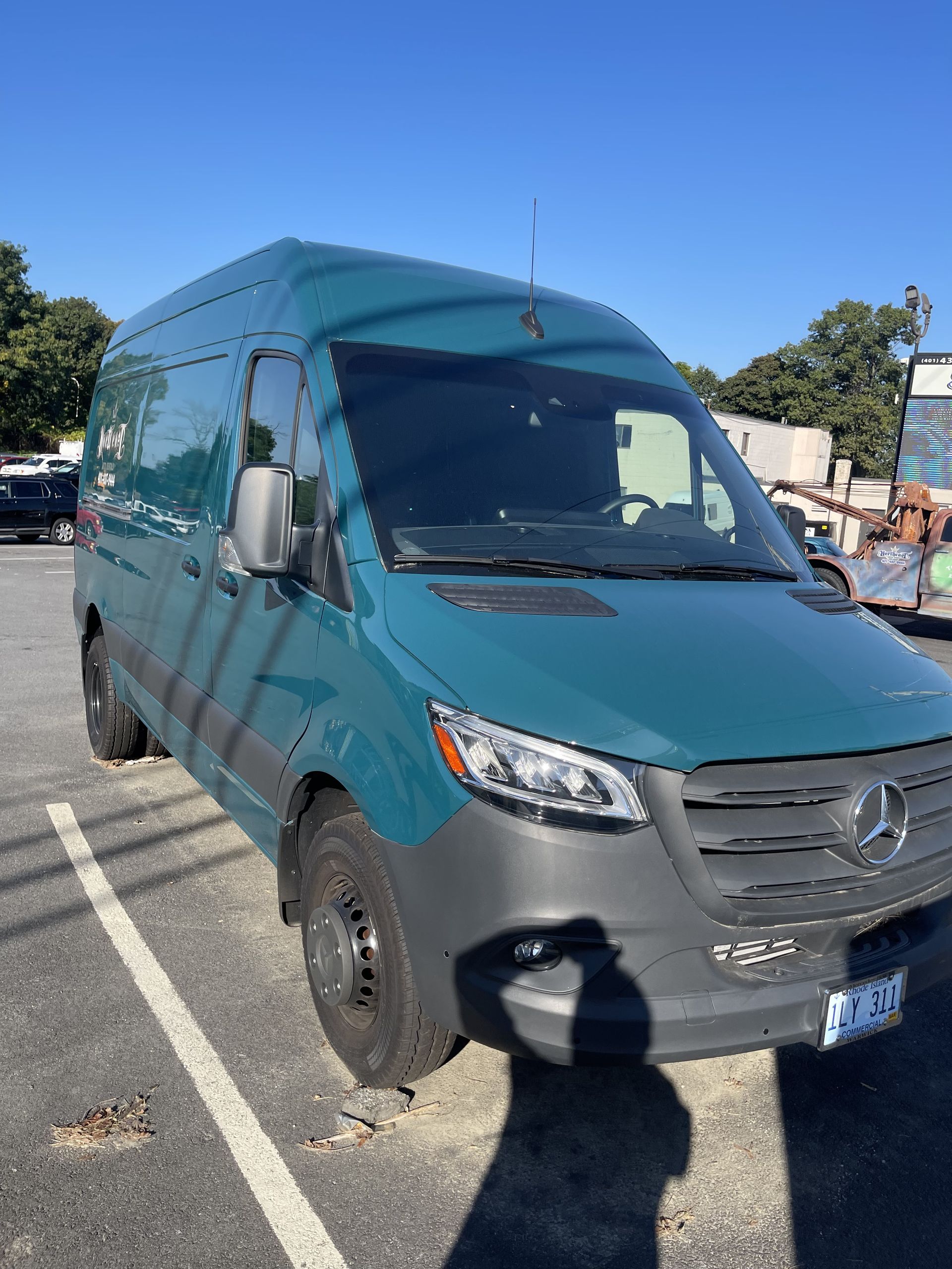A green van is parked in a parking lot.