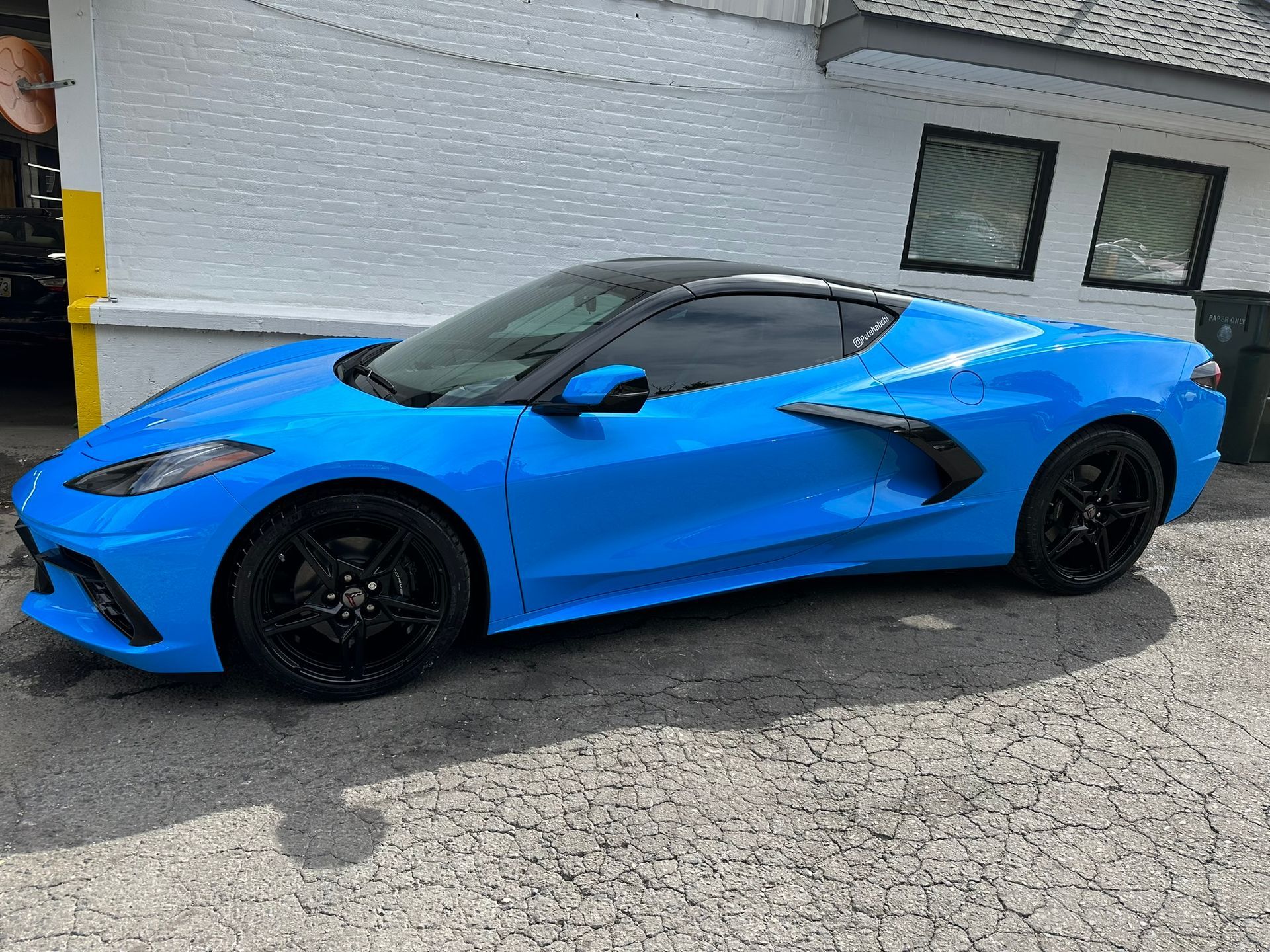 A blue sports car is parked in front of a building.
