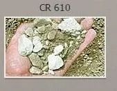 Hand holding a mix of green and white rocks and dust.