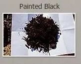Pile of black painted mulch on white paper.
