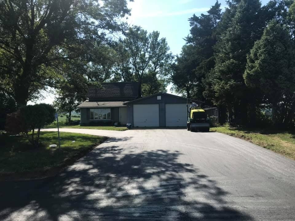 A house is sitting on the side of a road surrounded by trees.