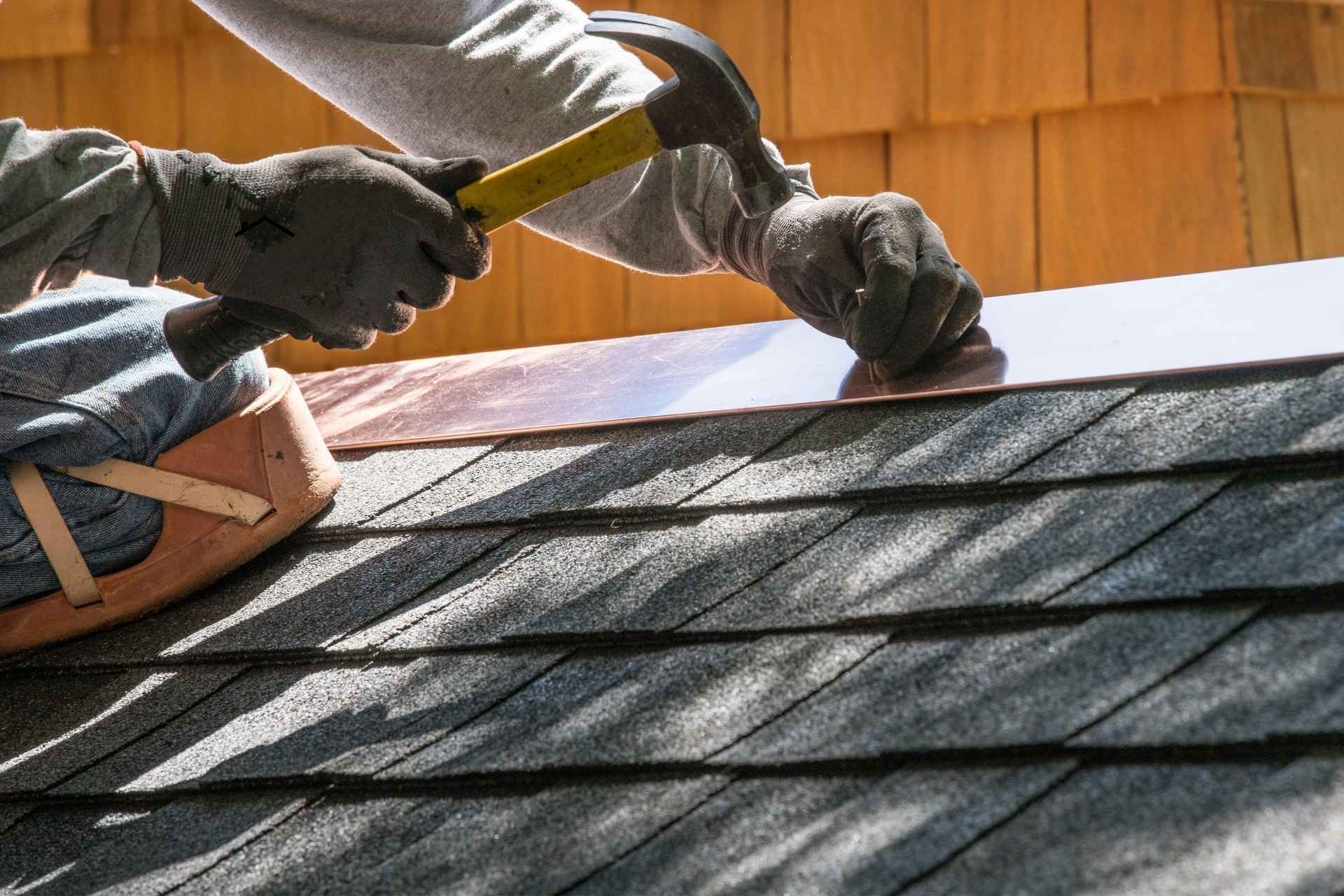 roofer hammering nail in eugene roof