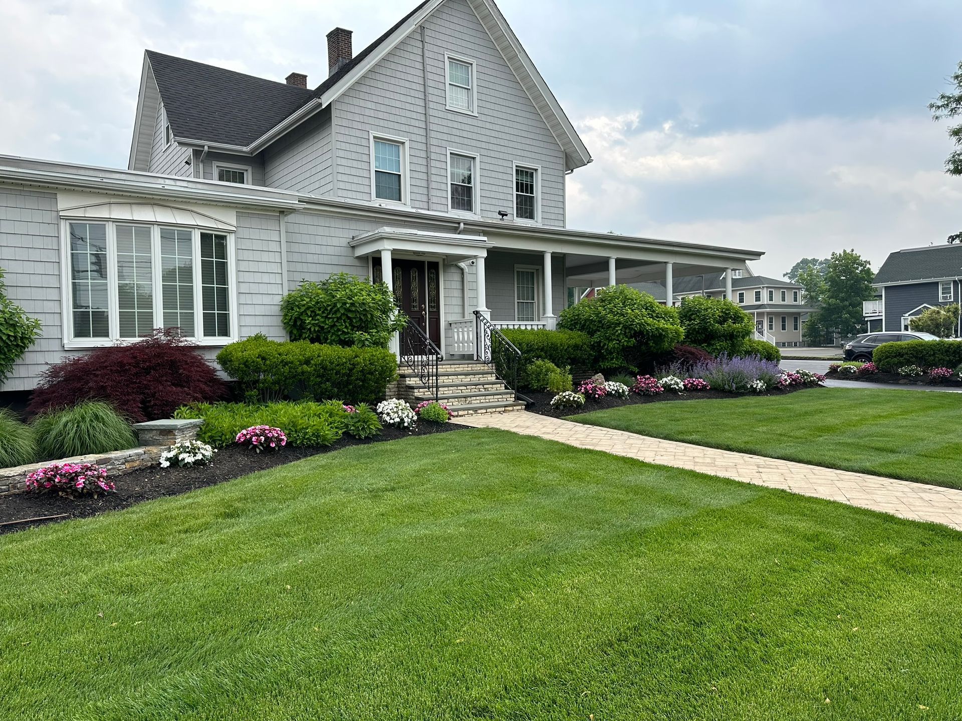 A large white house with a large lawn in front of it.