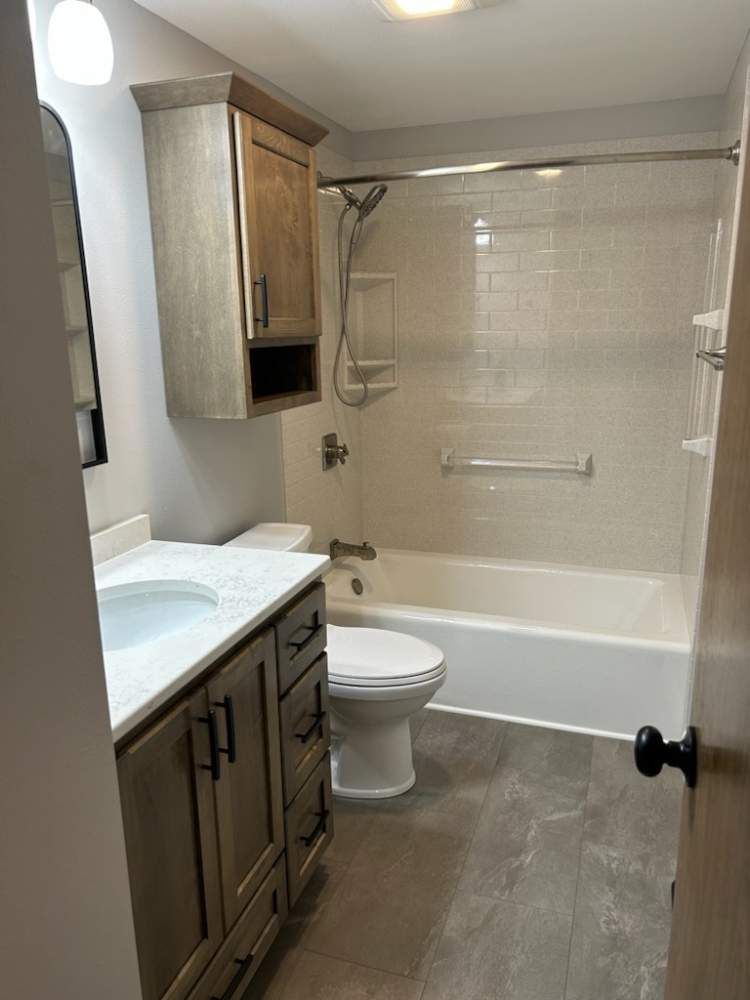 A bathroom with a toilet, sink, tub and shower.