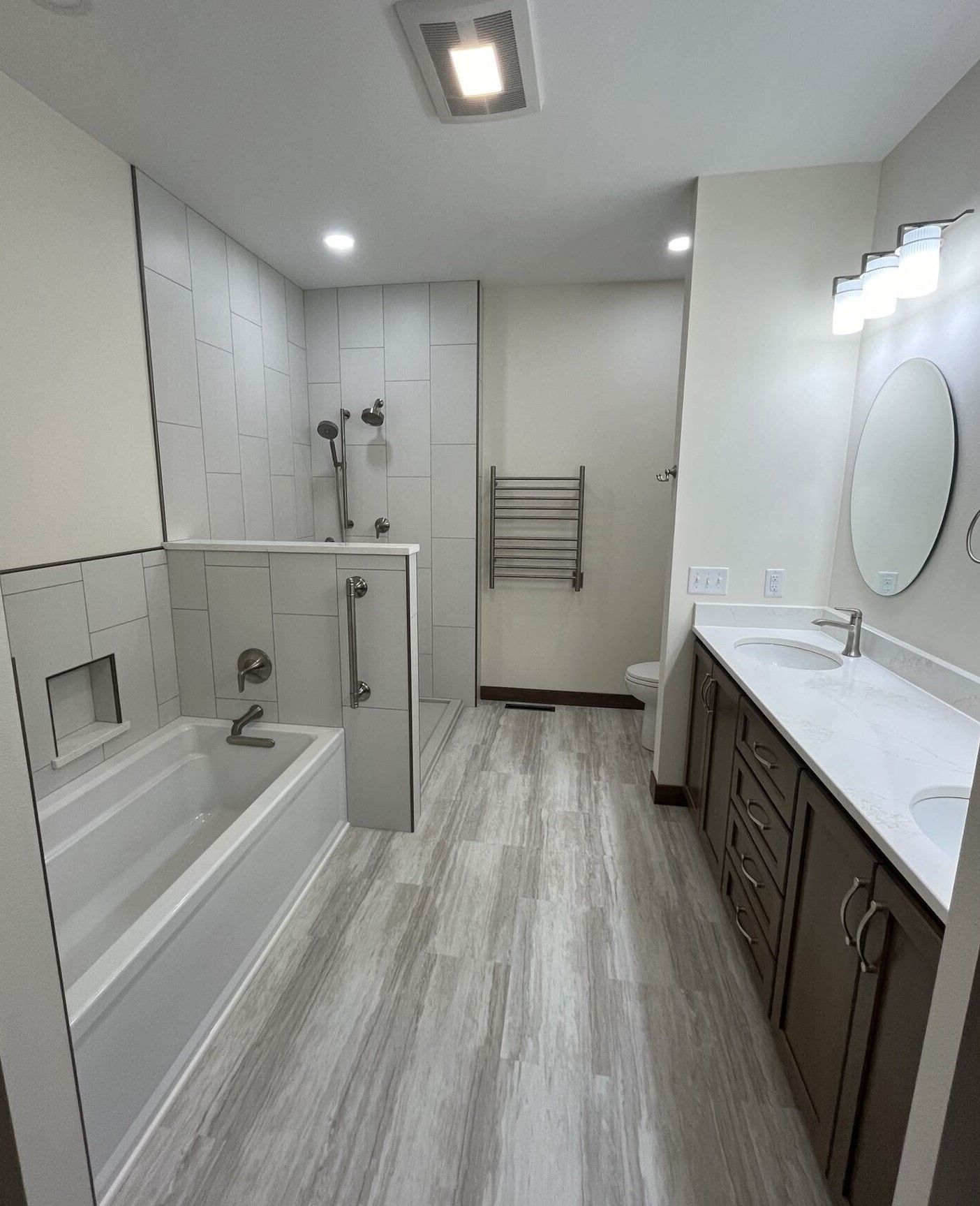 A bathroom with a bathtub, sink and mirror