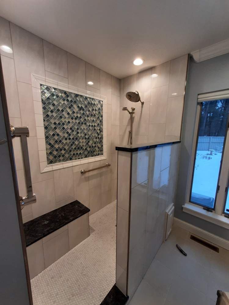 A bathroom with a walk in shower and a window.