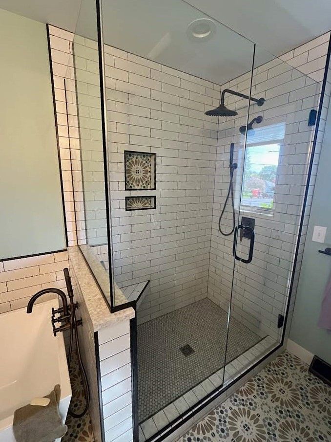 A bathroom with a walk in shower and a sink.