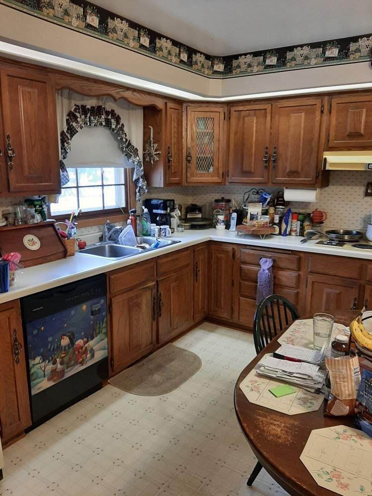 A kitchen with wood cabinets, a white countertop, and a dishwasher with a holiday-themed design.