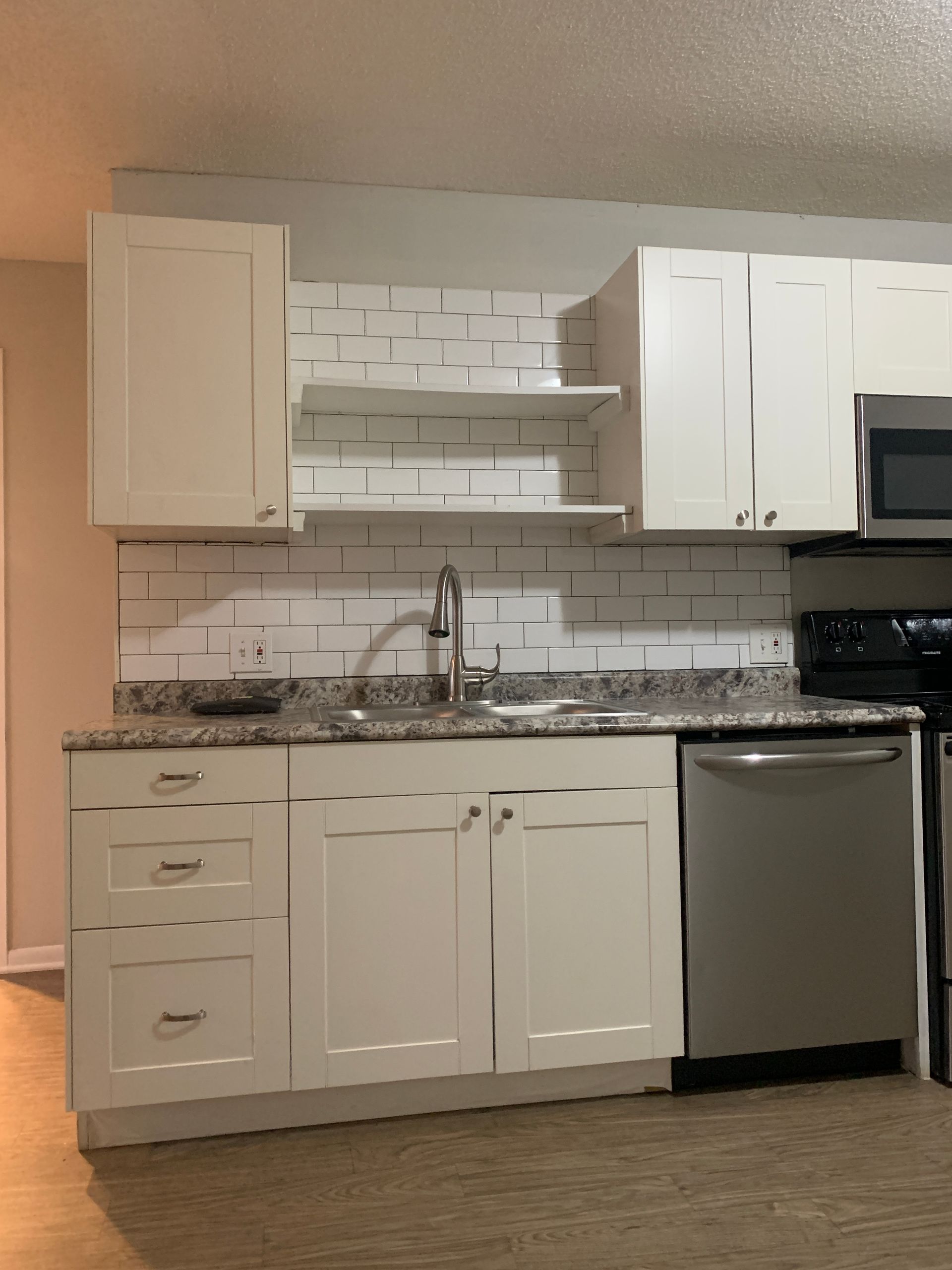Kitchen with white cabinets, stainless steel appliances, and granite countertops.