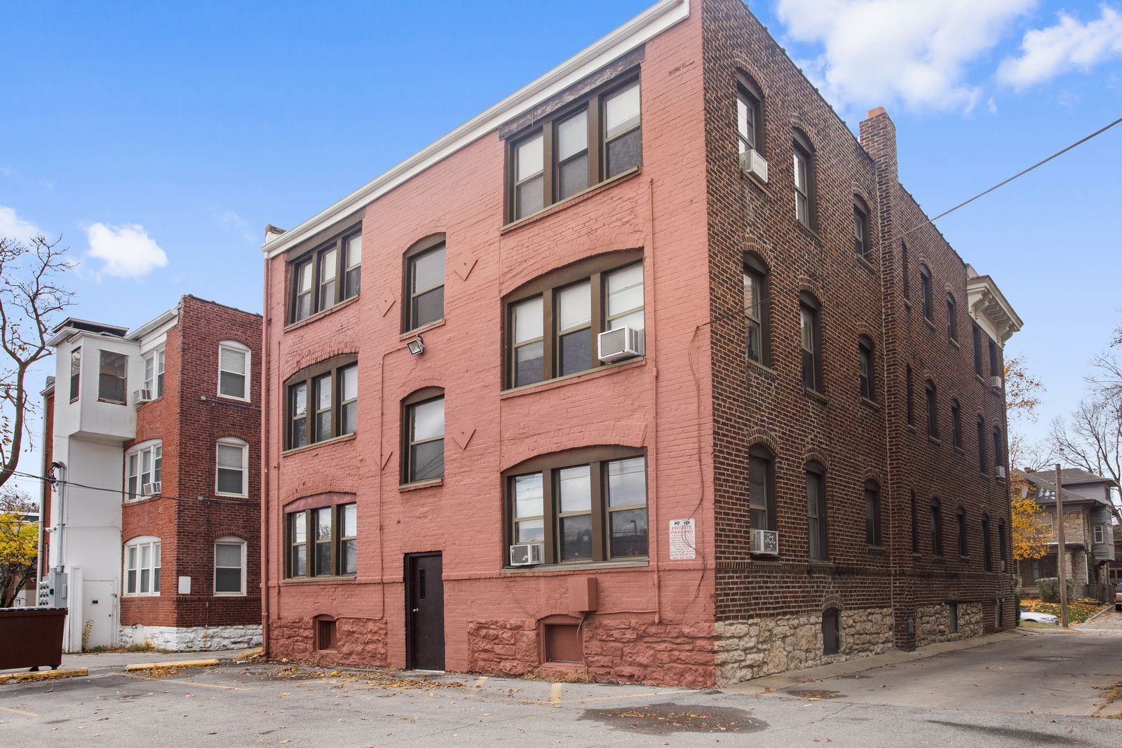 Multi-story brick building; pink and brown sections, windows. Exterior view.