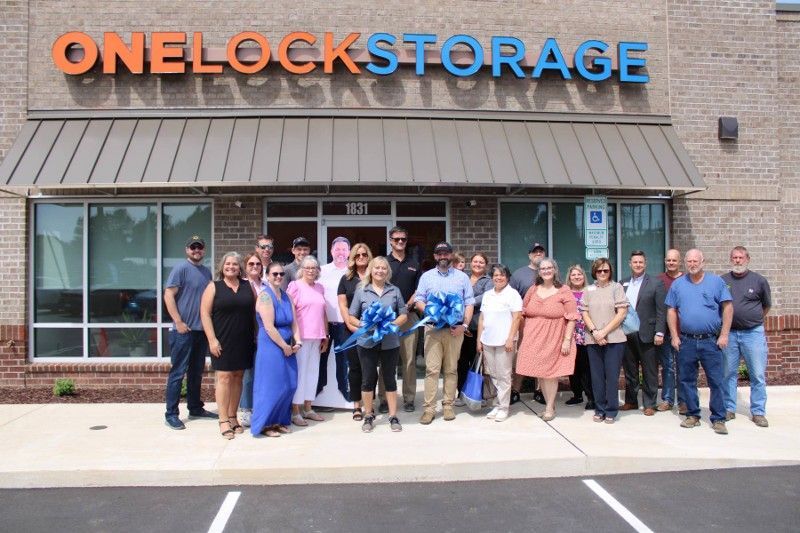 A group of people are standing in front of a onelock storage building.