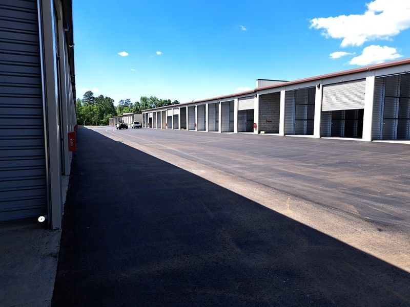 A parking lot with a row of buildings in the background