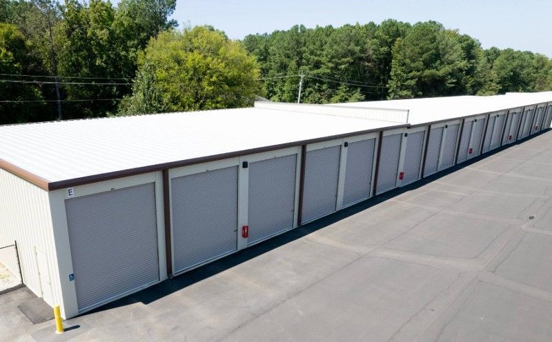 A row of garage doors are lined up in a parking lot.