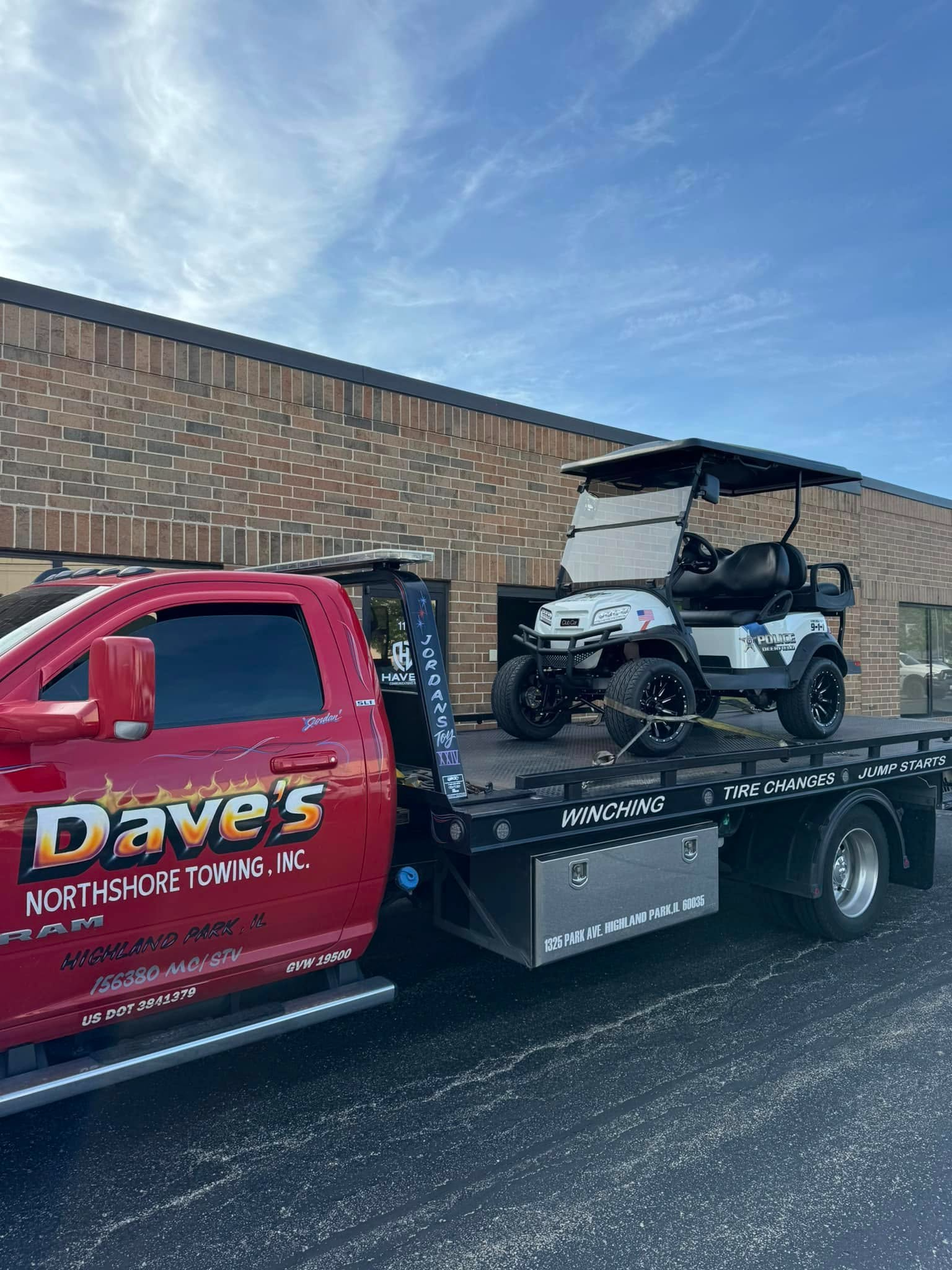 A golf cart is being towed by a tow truck.