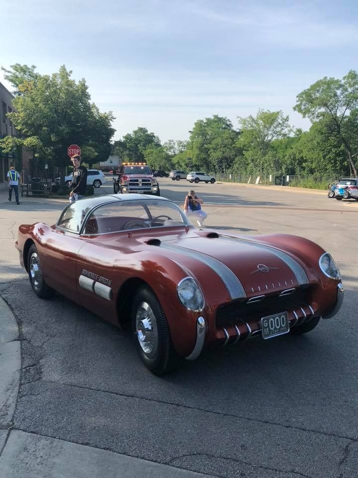 A red corvette is parked on the side of the road