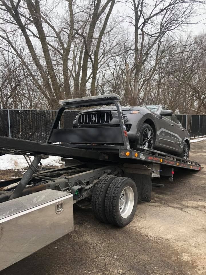 A car is sitting on top of a tow truck.