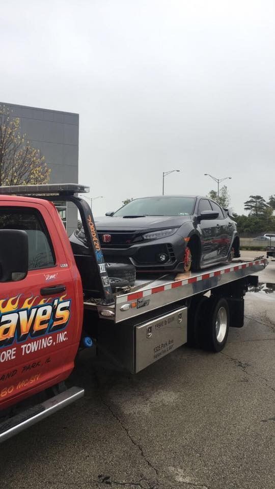 A car is being towed by a tow truck.