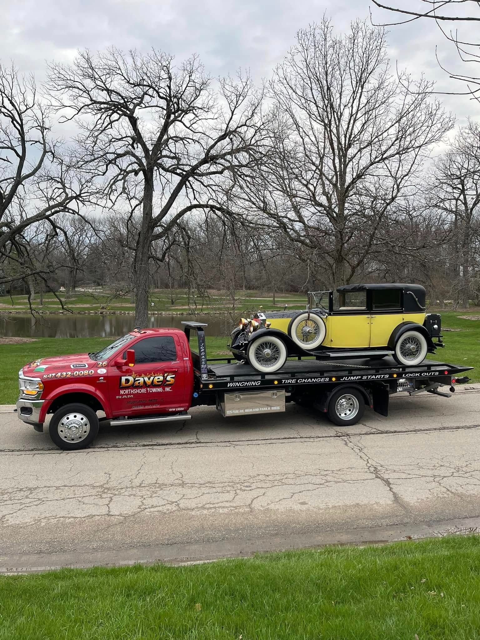 A red tow truck is towing a yellow car.