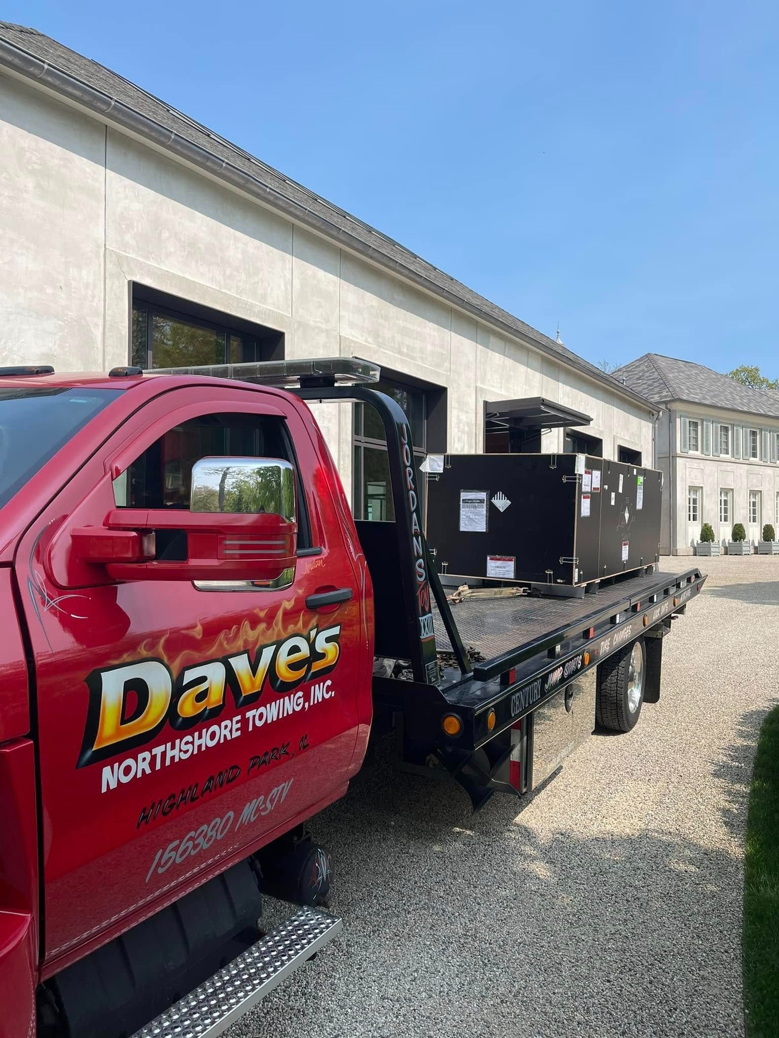 A red tow truck is parked in front of a building.