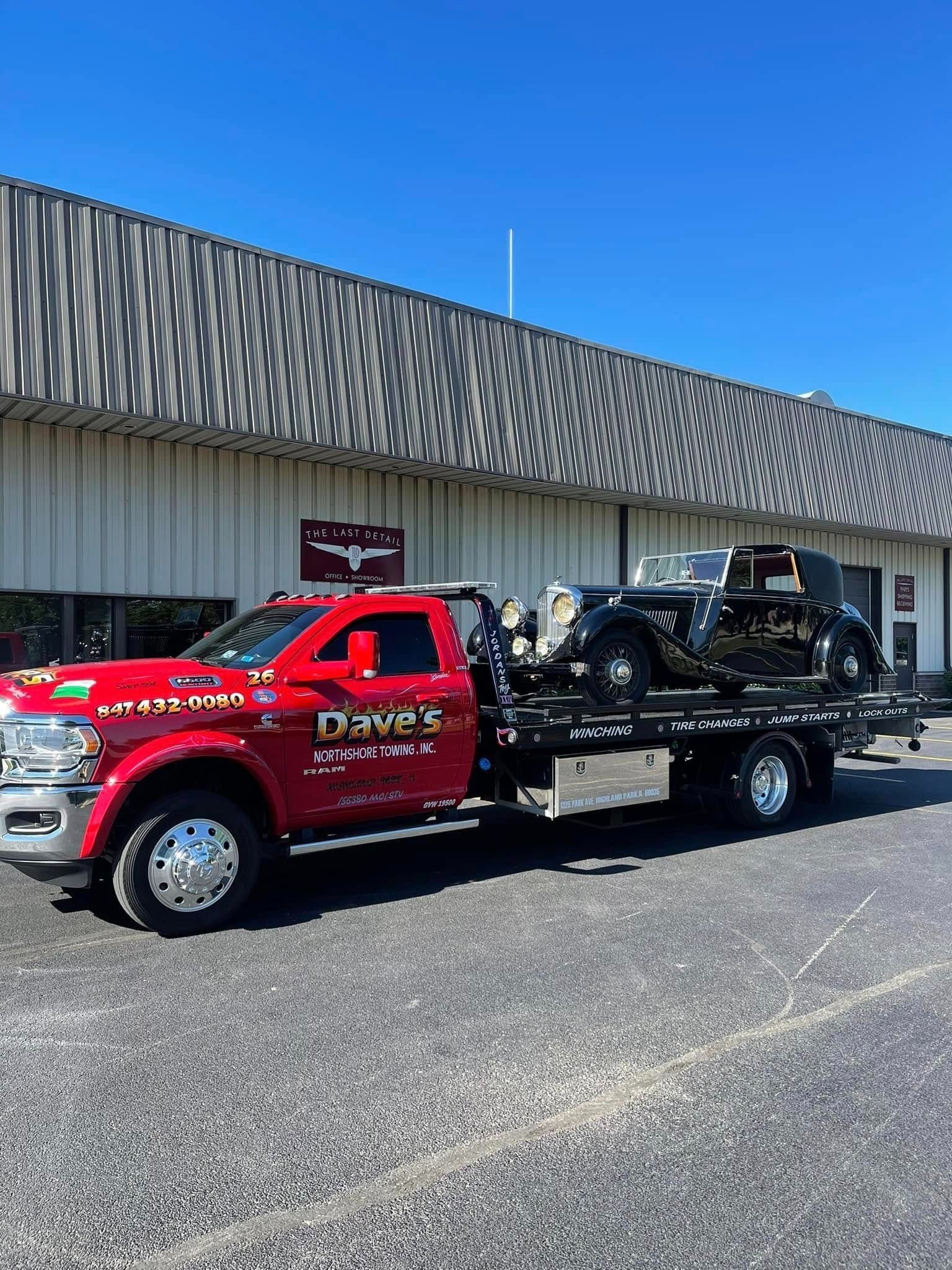 A red tow truck is parked in front of a building.