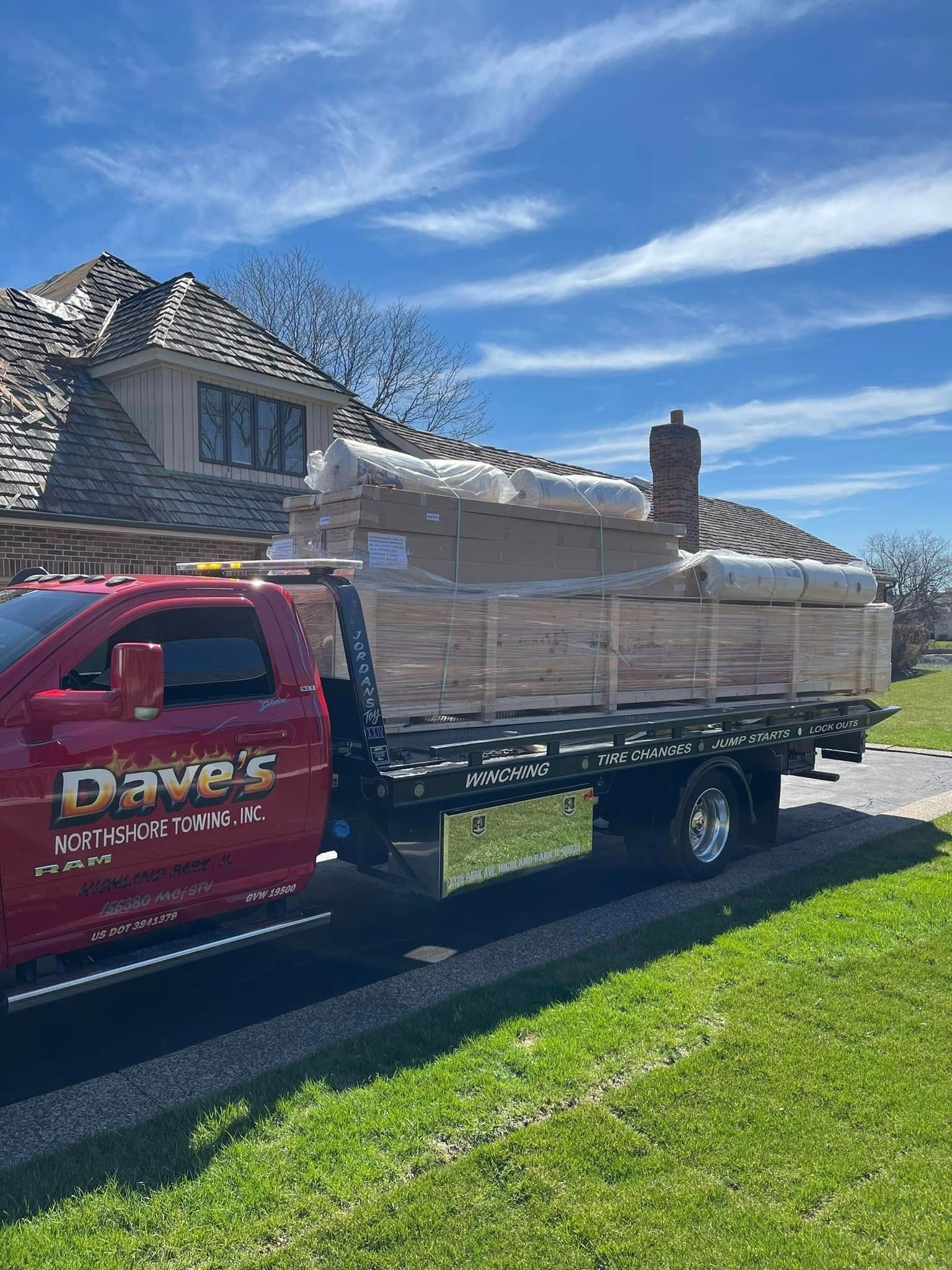 A red tow truck is parked in front of a house.