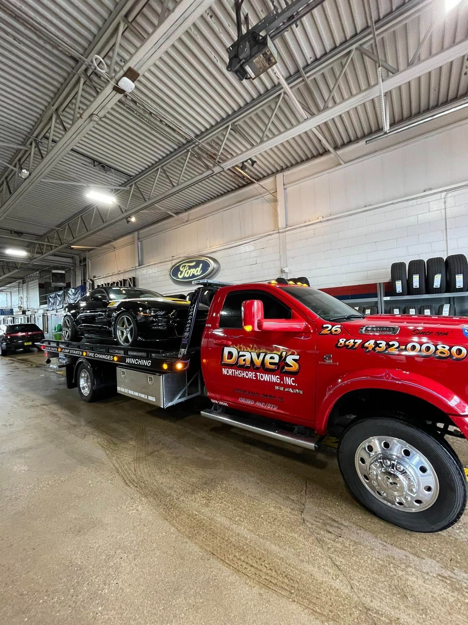 A red tow truck is parked in a garage.