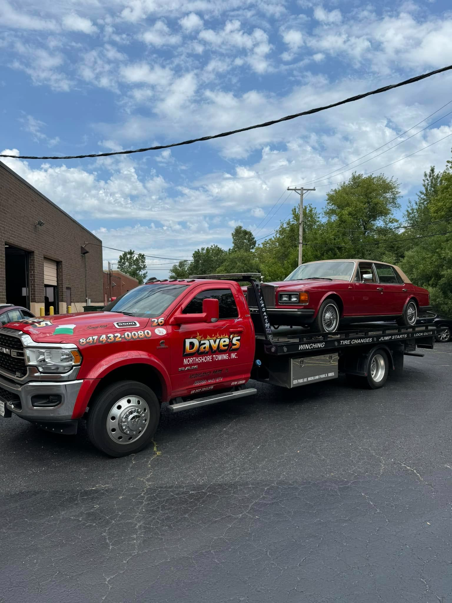 A red tow truck is towing a red car.