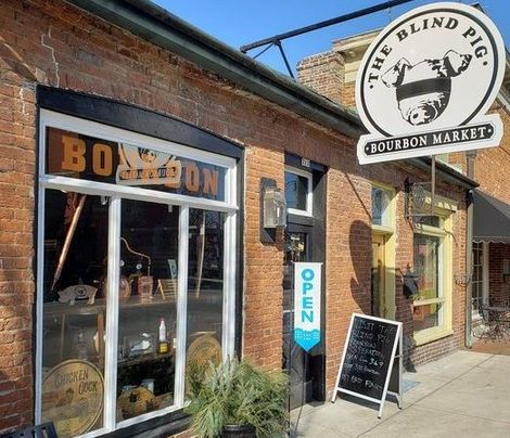 A brick building with a sign that says the blind pig bourbon market