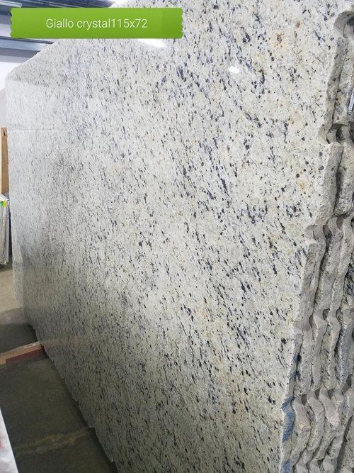 A large white granite slab is sitting in a warehouse.