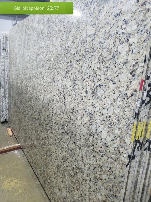 A large slab of granite is sitting on top of a concrete floor.