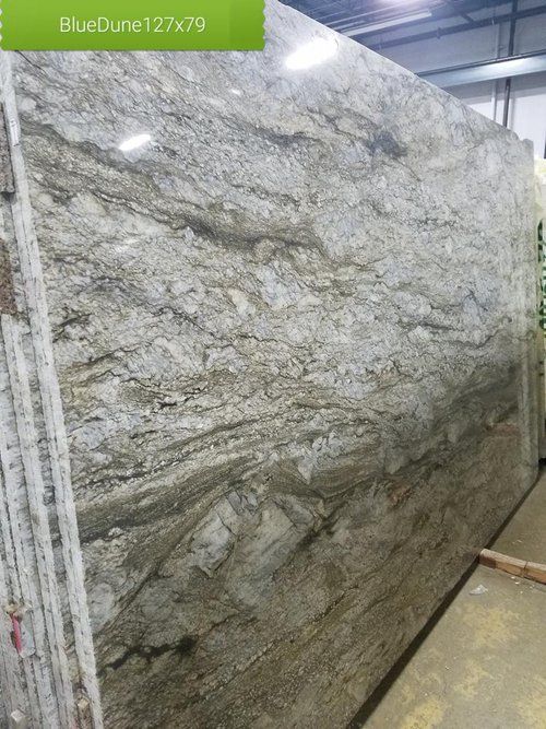 A large slab of granite is sitting in a warehouse.