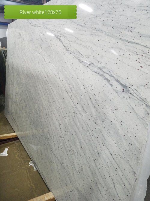 A large white granite slab is sitting on top of a wooden table.