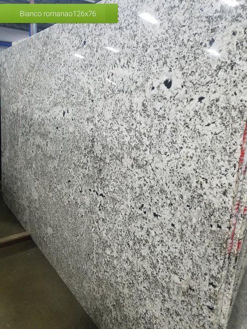 A large slab of white granite is sitting in a warehouse.