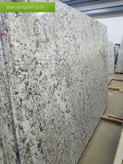 A large white granite slab is sitting on top of a wooden table.