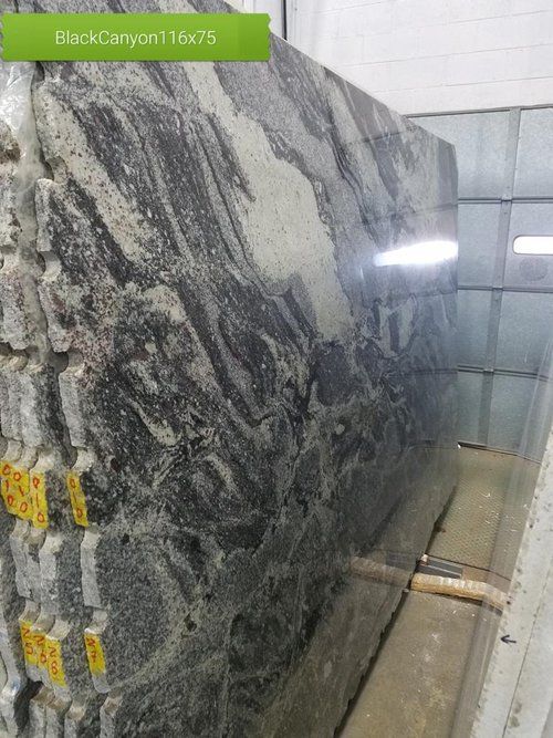 A large slab of granite is sitting on top of a wooden table.