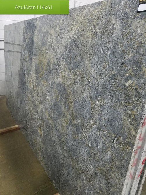 A large granite slab is sitting on the ground in a warehouse.