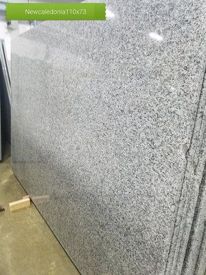 A large slab of granite is stacked on top of each other in a warehouse.