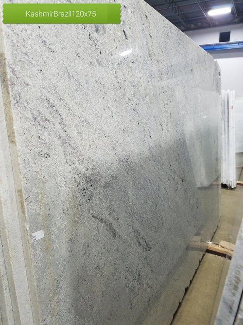 A large white granite slab is sitting in a warehouse.