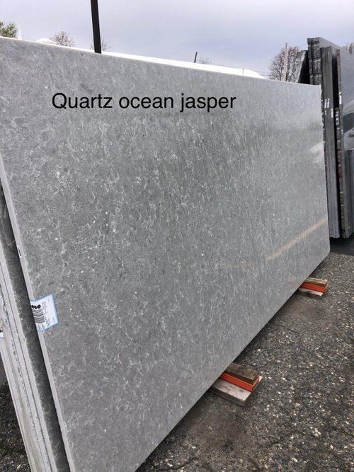 A large slab of quartz ocean jasper is sitting on the ground.
