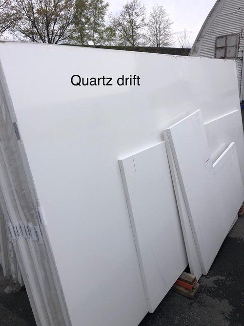 A large white slab of quartz drift is stacked on top of each other