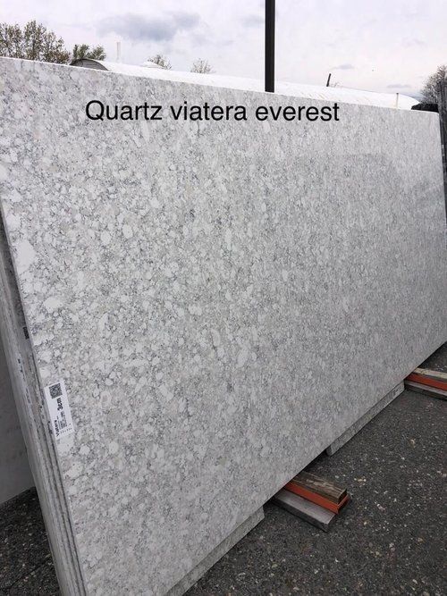 A large white granite slab is sitting on top of a concrete surface.