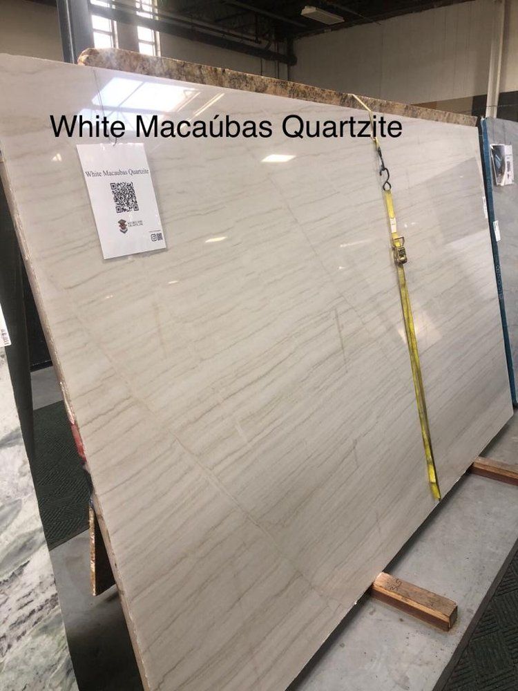 A large slab of white macaubas quartzite is sitting on top of a wooden stand.
