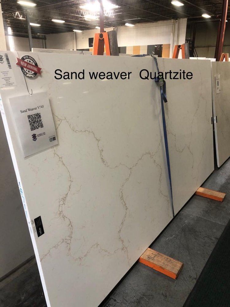 A large slab of sand weaver quartzite is sitting on wooden blocks in a warehouse.
