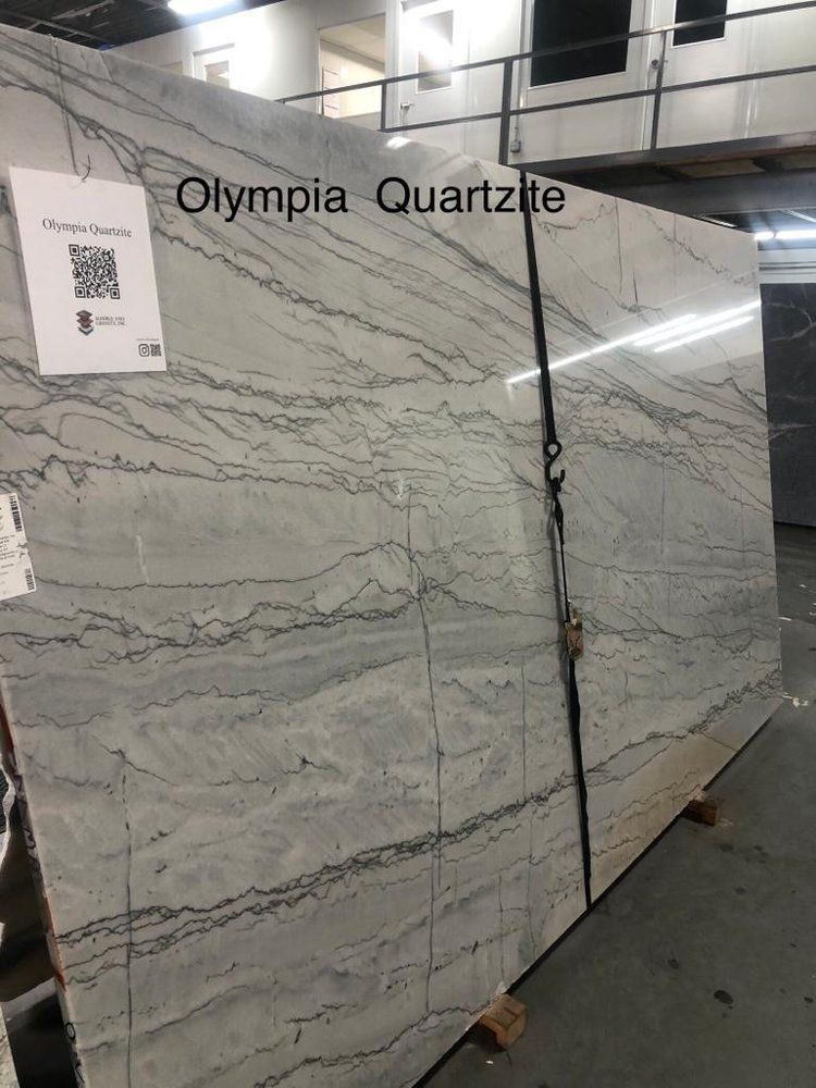 A large slab of olympia quartzite is sitting in a warehouse.