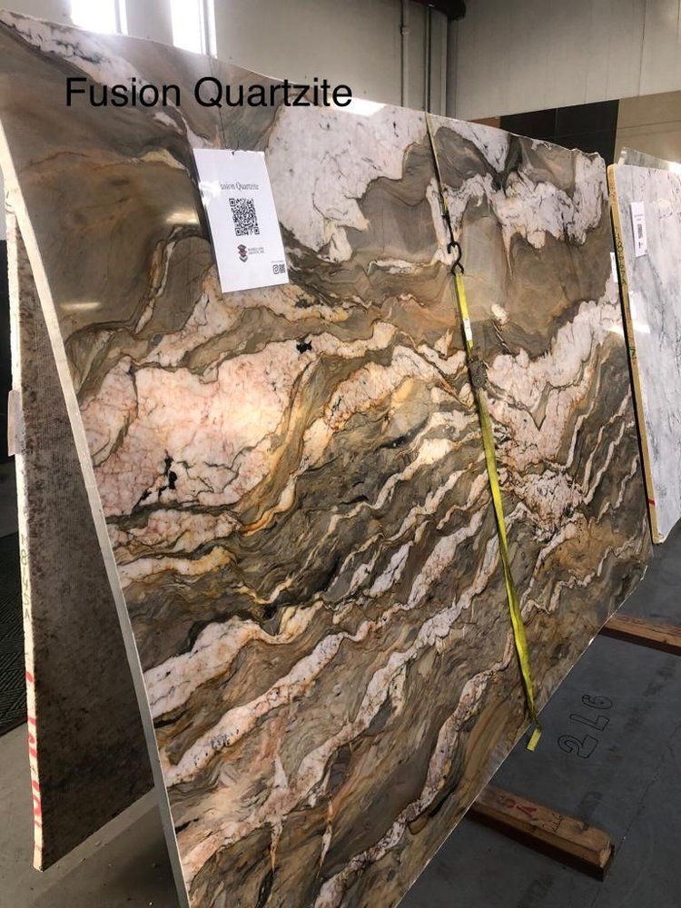 A large slab of fusion quartzite is sitting on top of a wooden table.