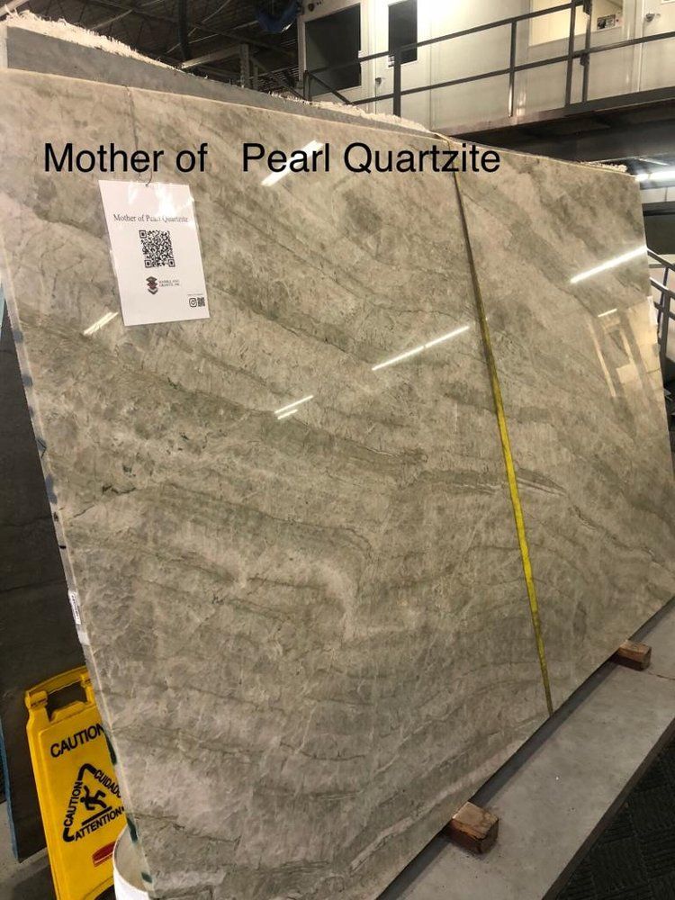 A large slab of mother of pearl quartzite is sitting on a table.