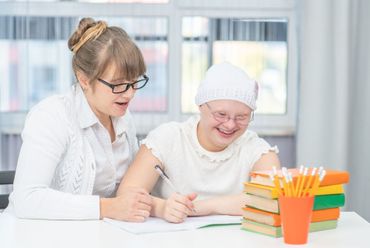 Learn More About Special Needs Trust (SNT) A woman is helping a girl with her document.