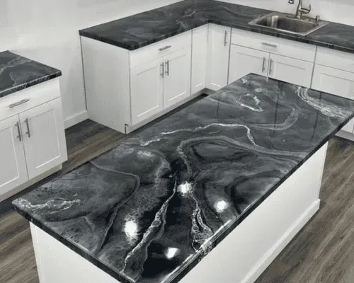 Kitchen with white cabinets and countertops with a black and white marbled epoxy finish